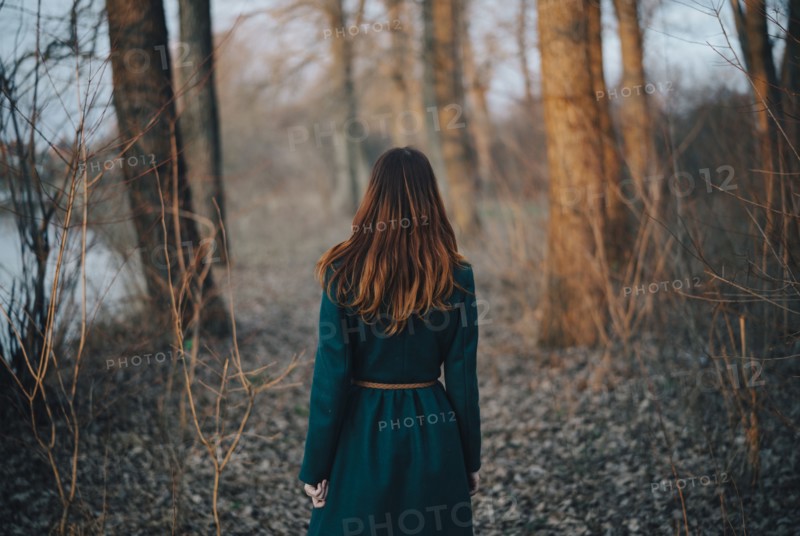 Caucasian woman standing near trees and river