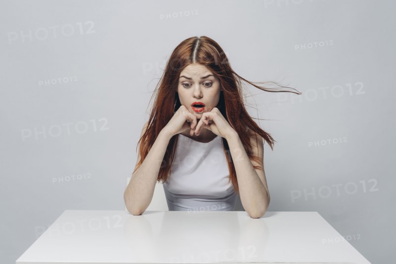 Surprised Caucasian woman sitting at windy table