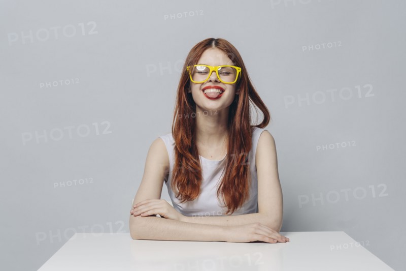 Caucasian woman sitting at table with tongue out