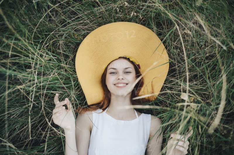 Caucasian woman wearing hat laying in grass