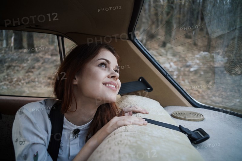 Caucasian woman in back seat of car looking up