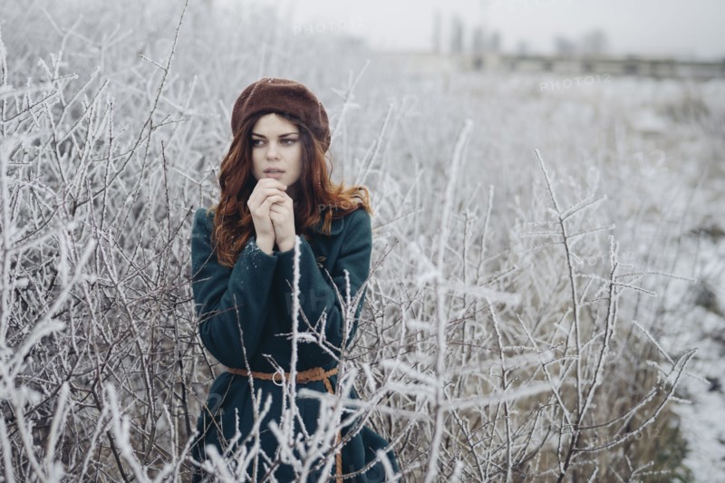 Caucasian woman rubbing hands in winter field