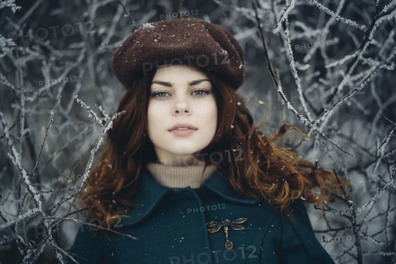 Serious Caucasian woman near icy branches
