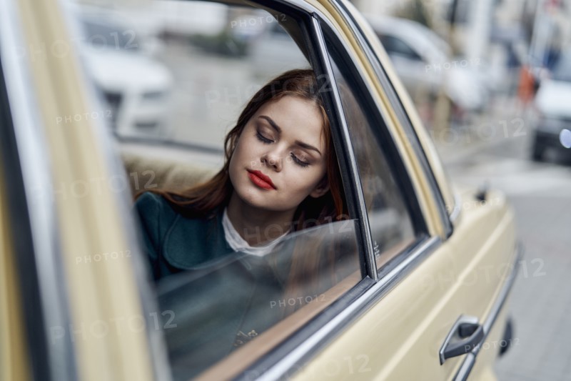 Caucasian woman sleeping in back seat of car