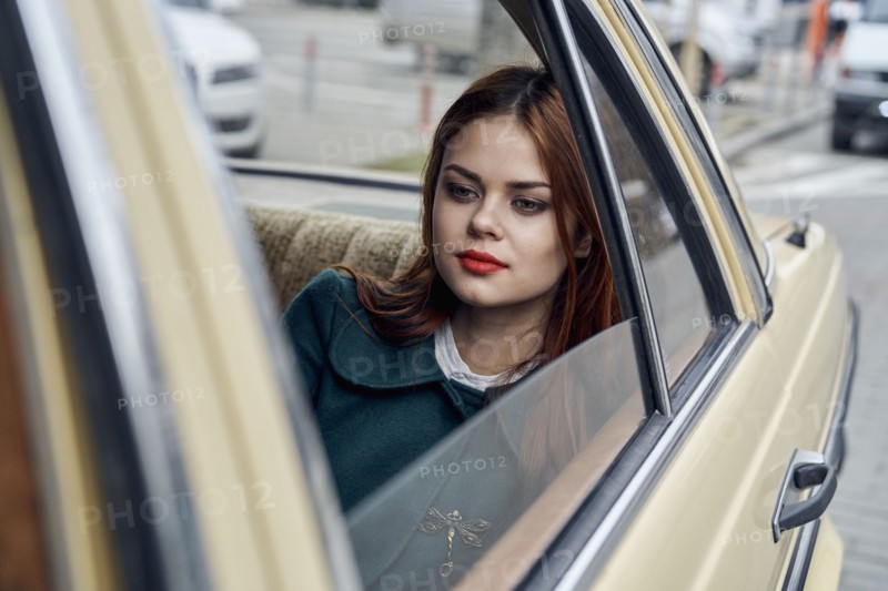 Pensive Caucasian woman in back seat of car