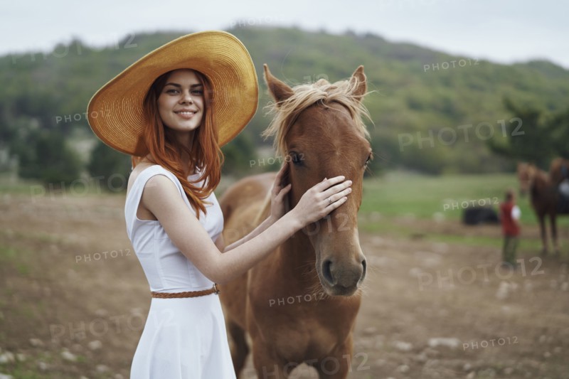 Smiling woman petting horse