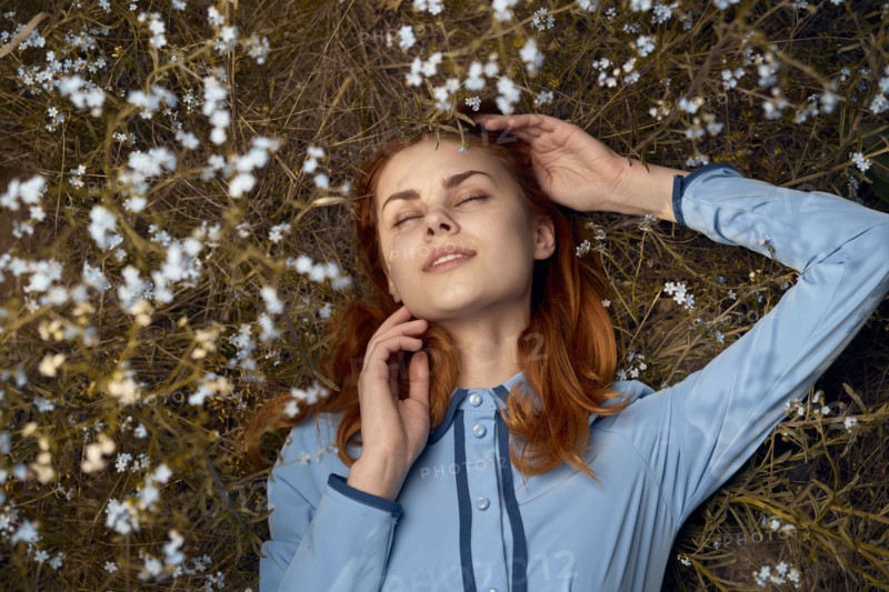 Caucasian woman laying in field of wildflowers