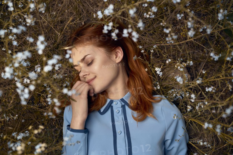Caucasian woman laying in field of wildflowers