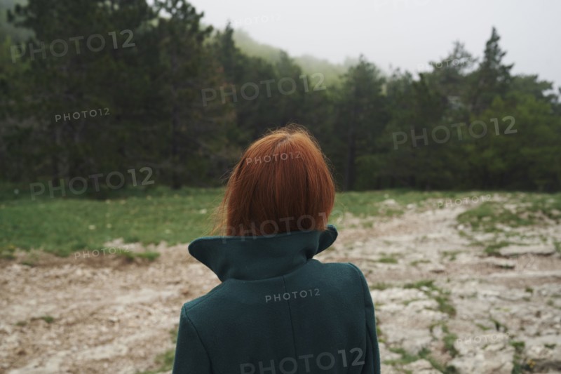 Caucasian woman wearing a coat with a collar in field