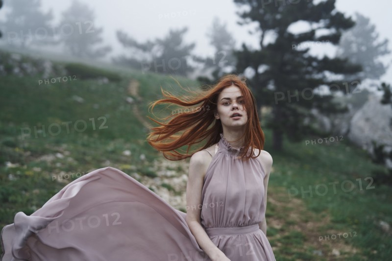 Wind blowing hair of Caucasian woman in field