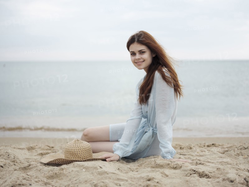 Smiling Caucasian woman sitting on beach
