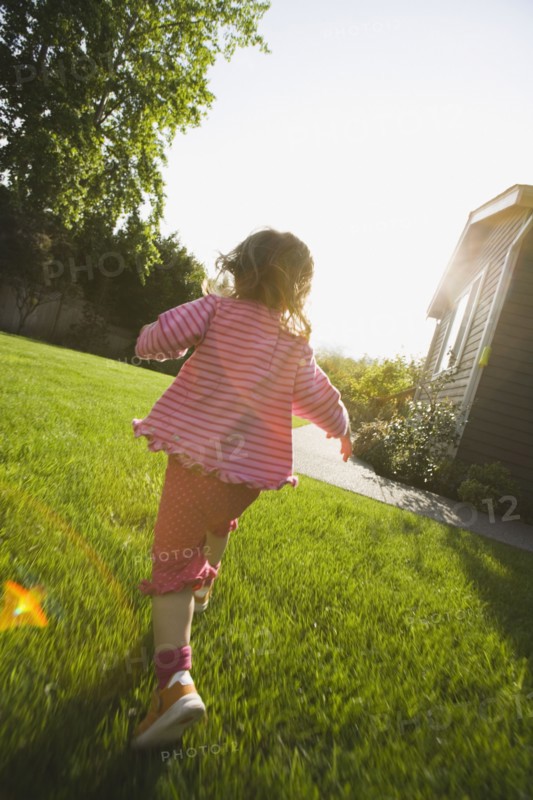 Back of girl running in back yard