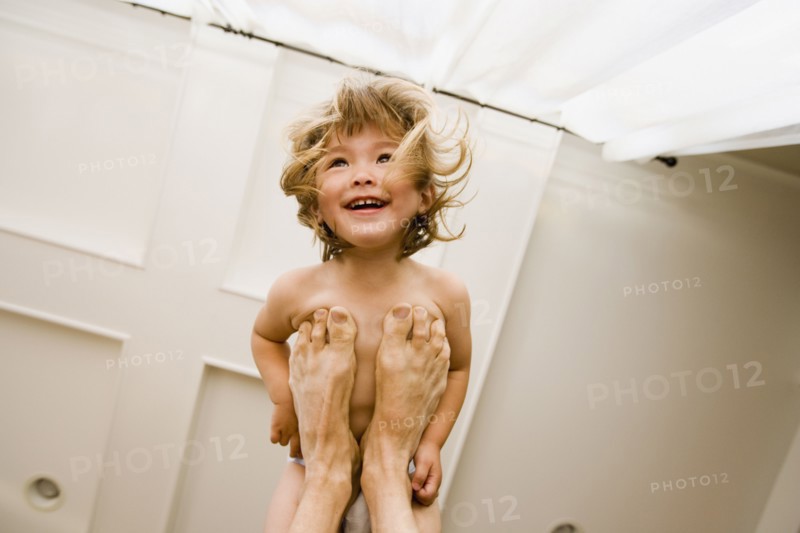 Portrait of girl balanced on father's feet