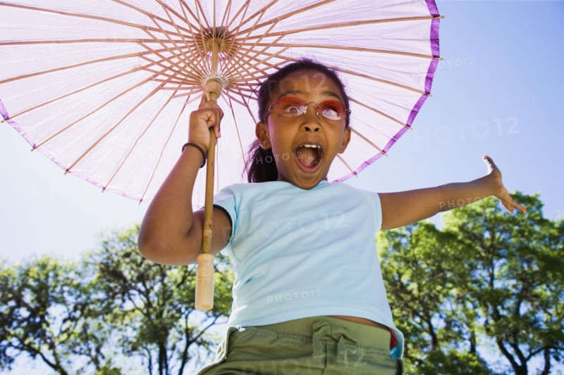 African American girl laughing with parasol outdoors