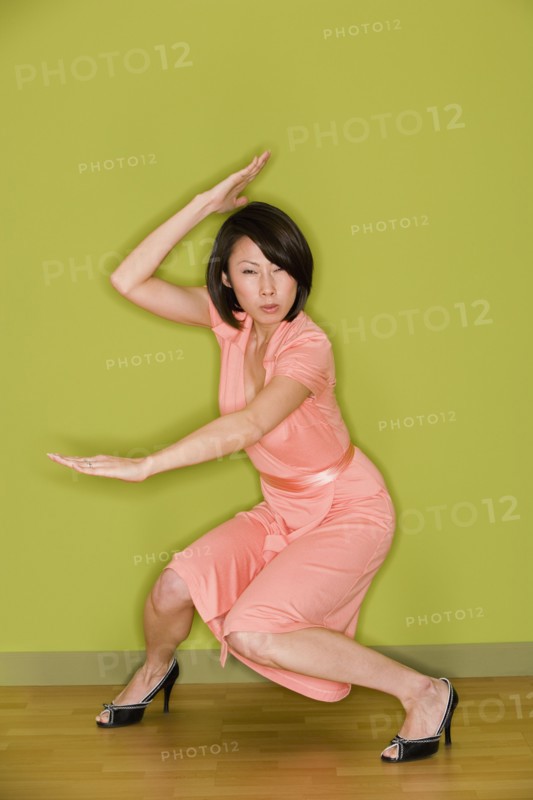 Asian woman in dress doing martial arts move