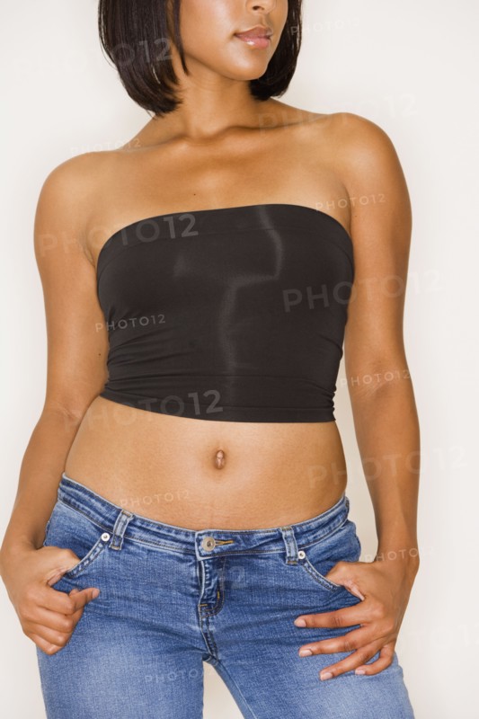 Studio shot of young Hispanic woman in strapless top and jeans