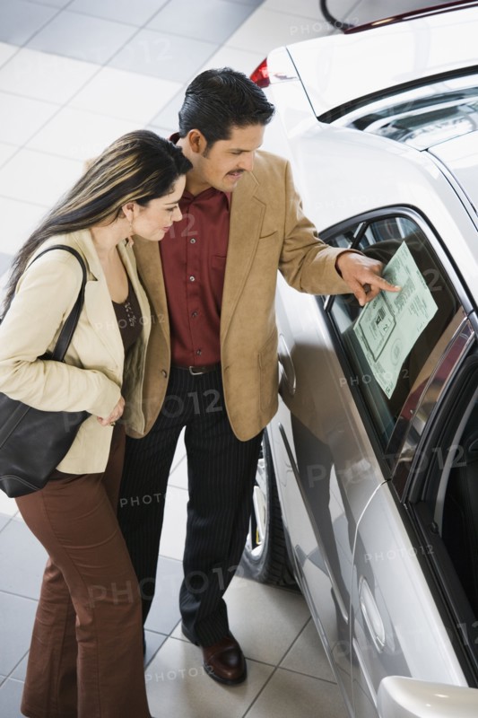 Hispanic couple looking at new car
