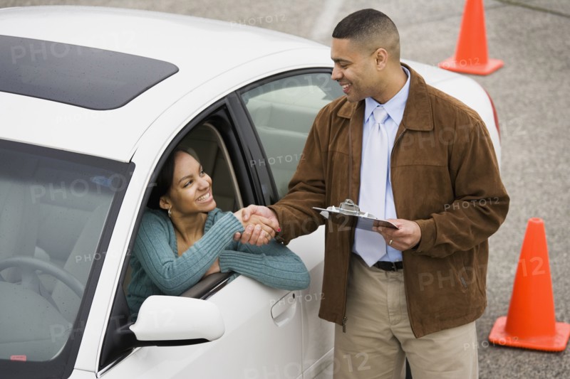 African teenager shaking hands with driving instructor