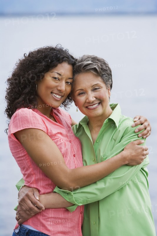 African American mother and adult daughter hugging