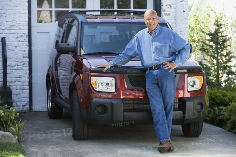 Senior African American man leaning on car