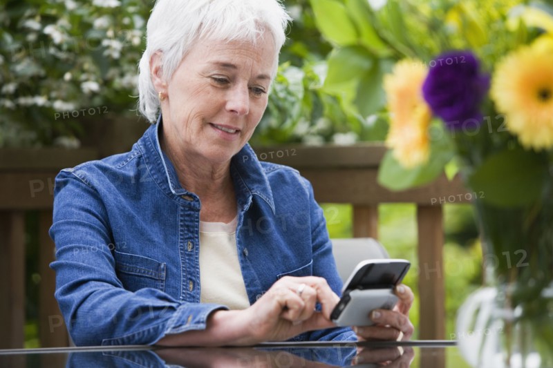 Senior woman using electronic organizer outdoors