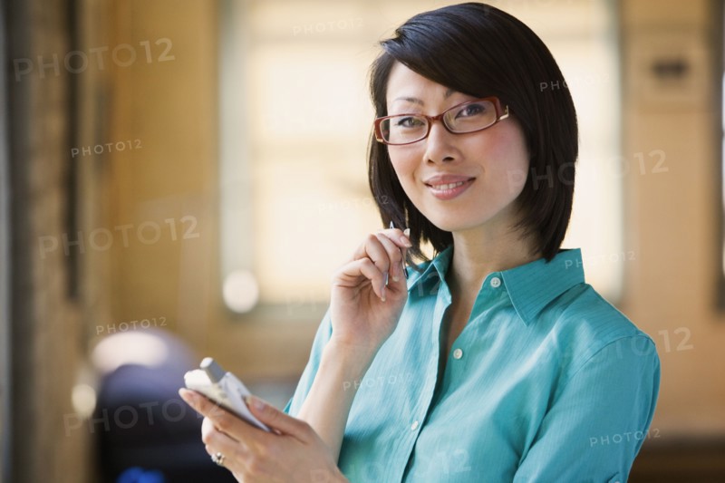 Asian woman smiling with electronic organizer