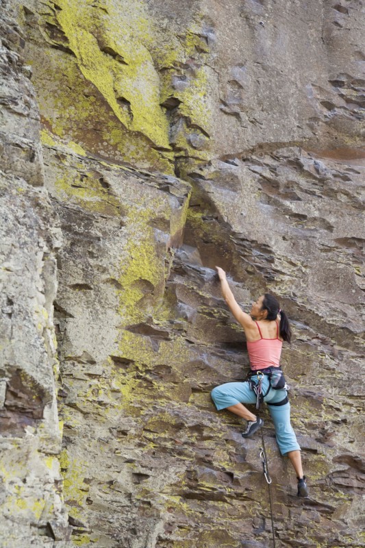 Asian woman rock climbing