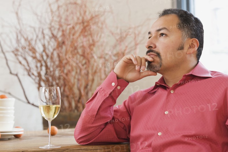 Hispanic man next to glass of wine