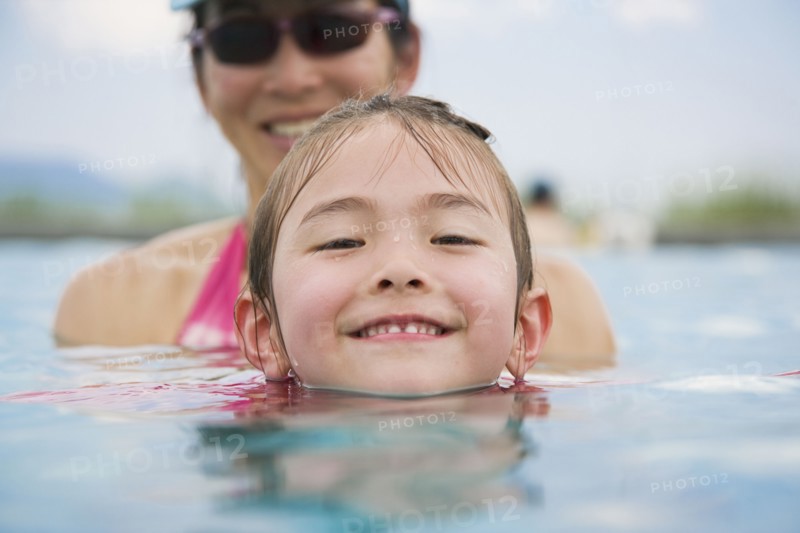 Asian girl and mother in swimming pool