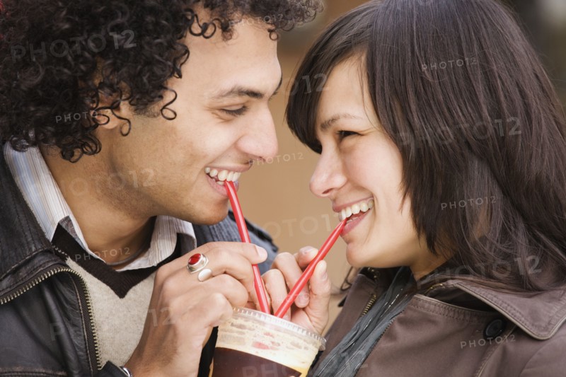 Couple drinking from one cup