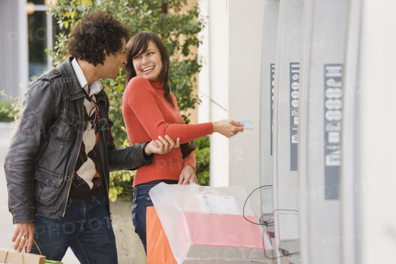 Couple with shopping bags at ATM
