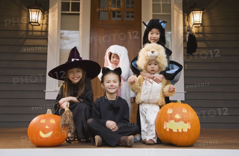 Children in Halloween costumes with pumpkins