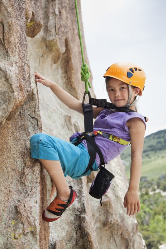 Mixed race girl rock climbing