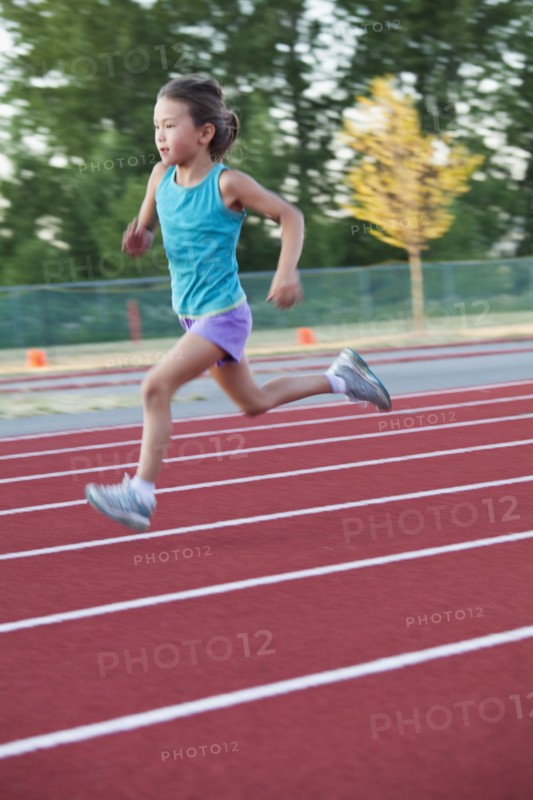 Mixed race girl running on track