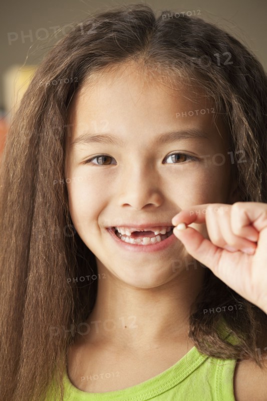 Mixed race girl holding toothy
