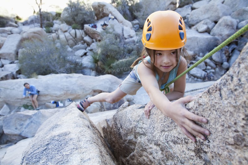 Mixed race girl rock climbing