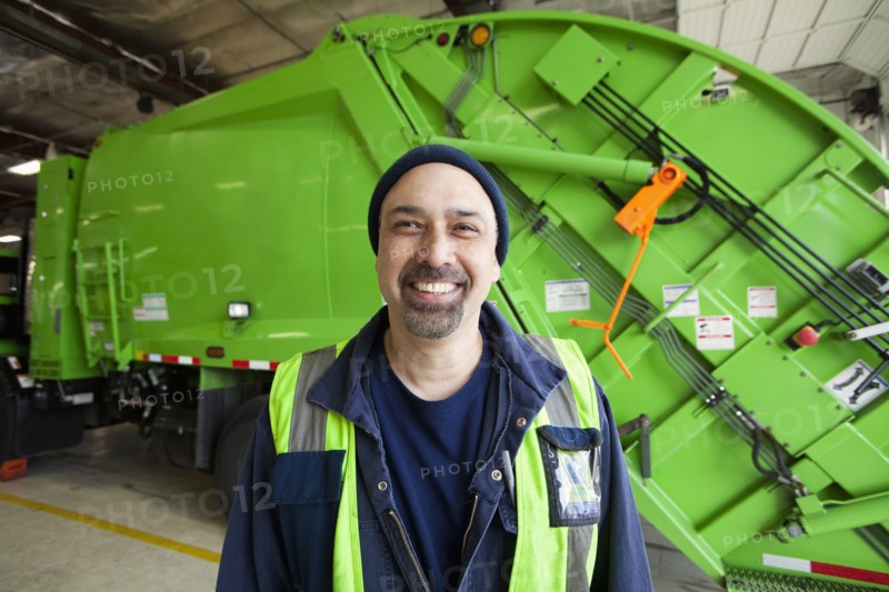 Pacific Islander man standing by garbage truck