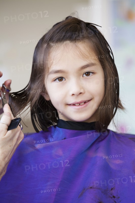 Mixed race girl getting her hair cut