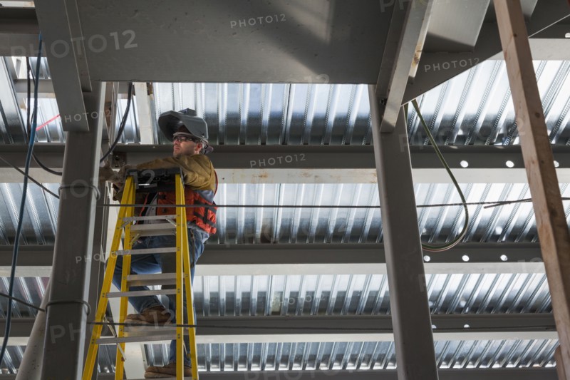 Caucasian construction worker standing on ladder
