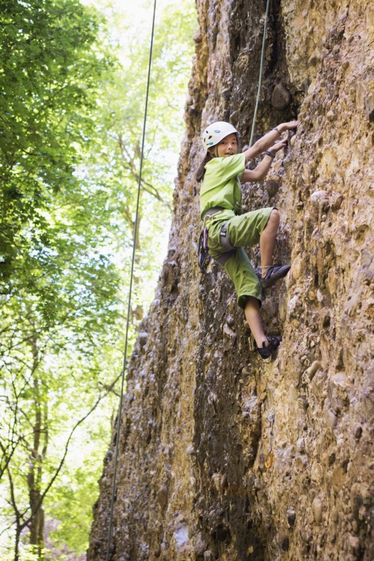 Mixed race girl rock climbing