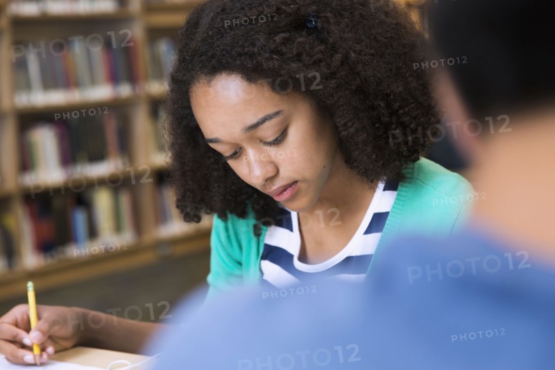 Female student taking notes in library