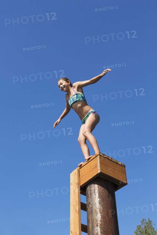 Mixed race girl jumping off platform