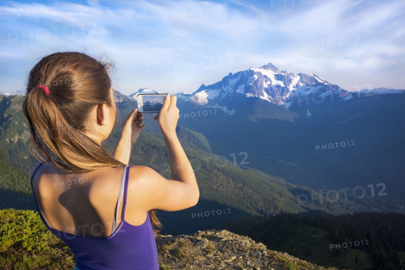 Mixed race girl photographing mountains