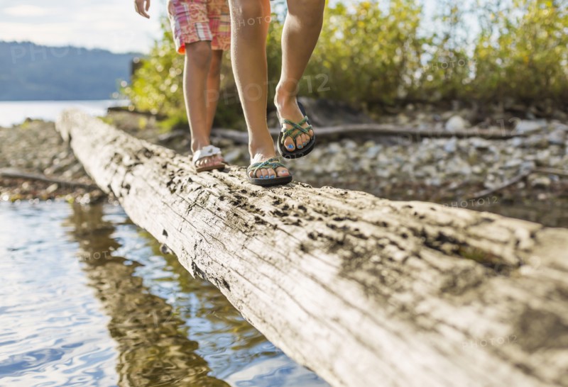 Mixed race children walking on log