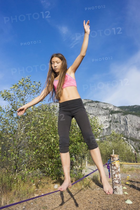 Mixed race girl walking on tightrope