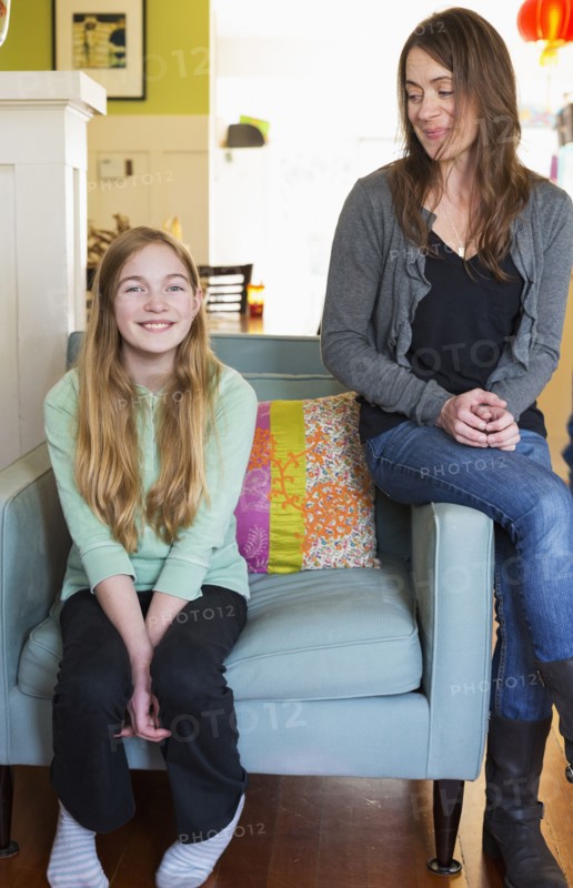 Caucasian mother and daughter smiling in living room