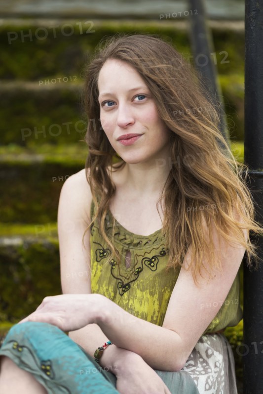 Caucasian teenage girl sitting on steps outdoors
