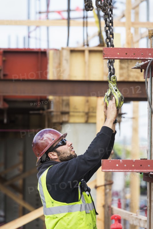 Caucasian worker holding hook at construction site