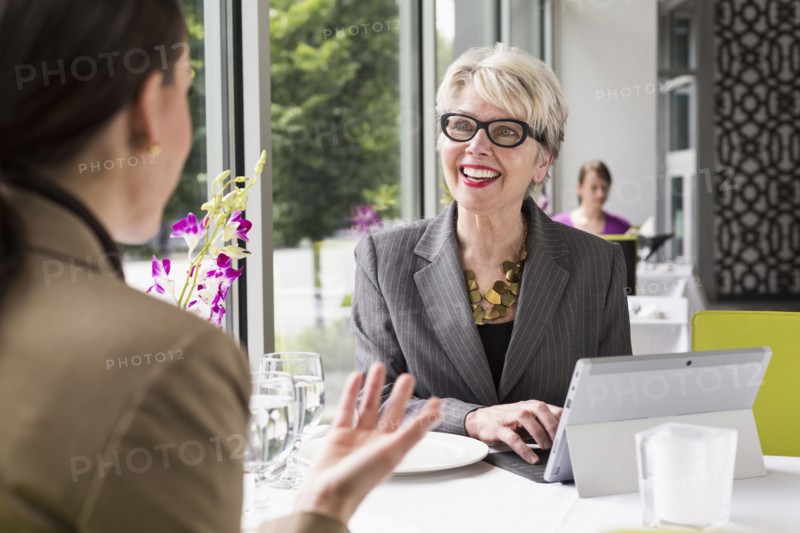 Caucasian businesswomen working in restaurant