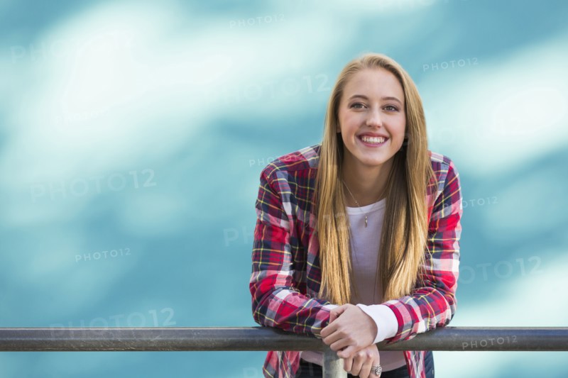 Smiling Caucasian woman leaning on banister